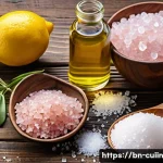 Home 22 비건 요리에 어울리는 맛있는 소금 종류 - A high-resolution still life composition showcasing three distinct types of salt used in vegan cooki...